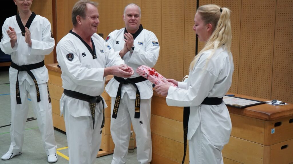 Momme Knutzen überreicht Laura Bredahl die Urkunde zum 3. Dan – Taekwondo beim TSB Flensburg